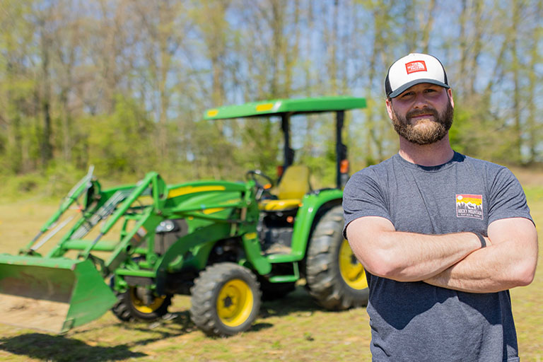 man standing outside in front of tractor