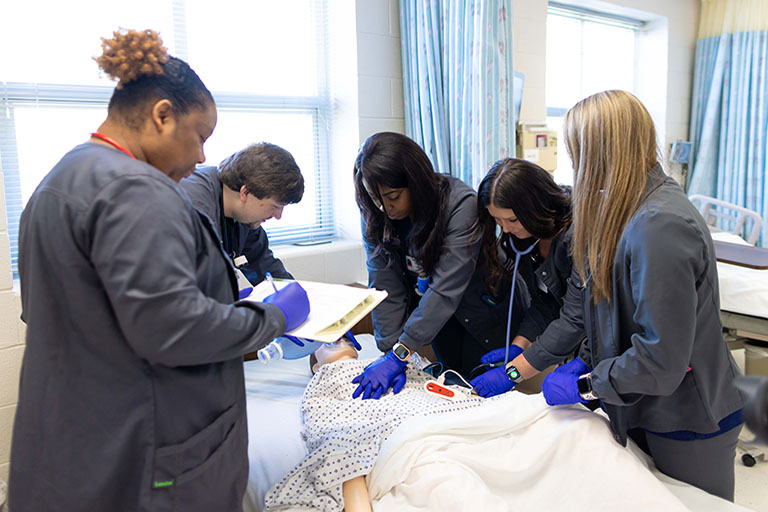 Nursing student practicing on manican