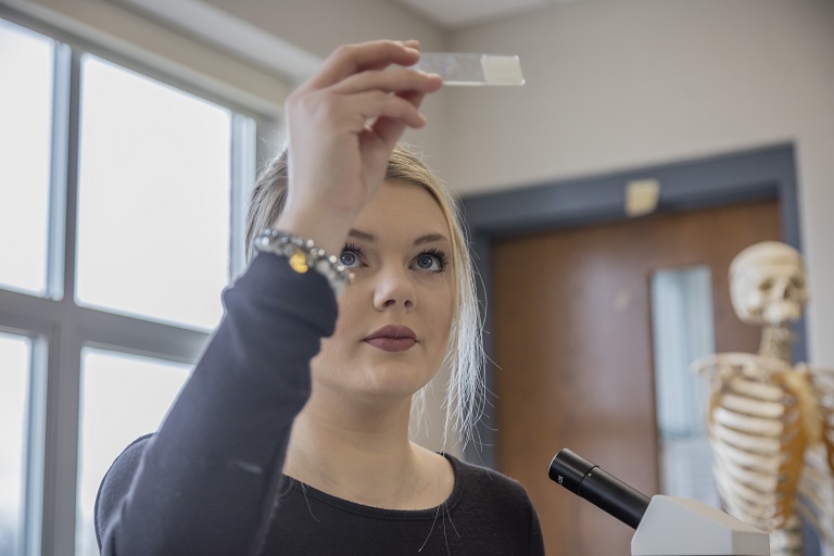 girl looking at a microscope slide