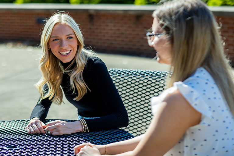 two girls sitting at a patio table